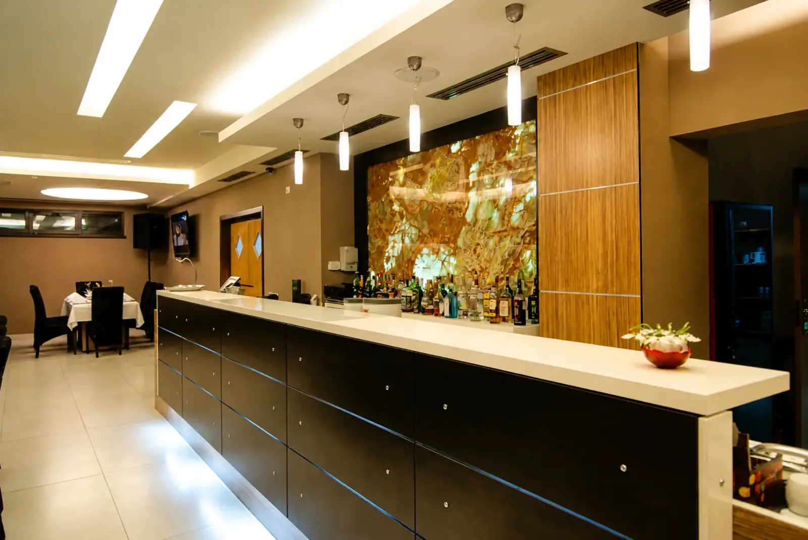Bar counter and restaurant seating at Hotel Ave Lux