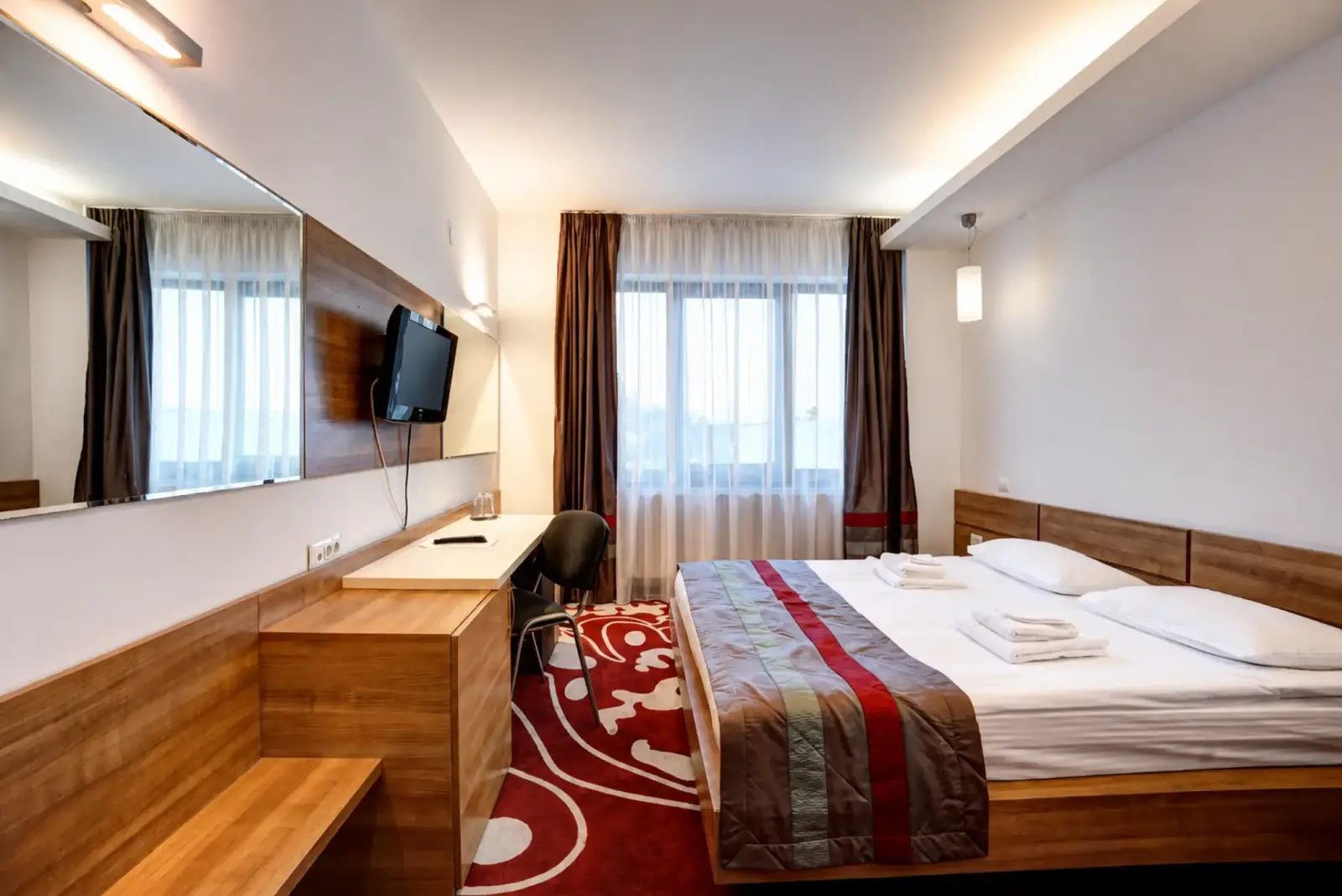 King room at Hotel Ave Lux with a desk, mirror and large window