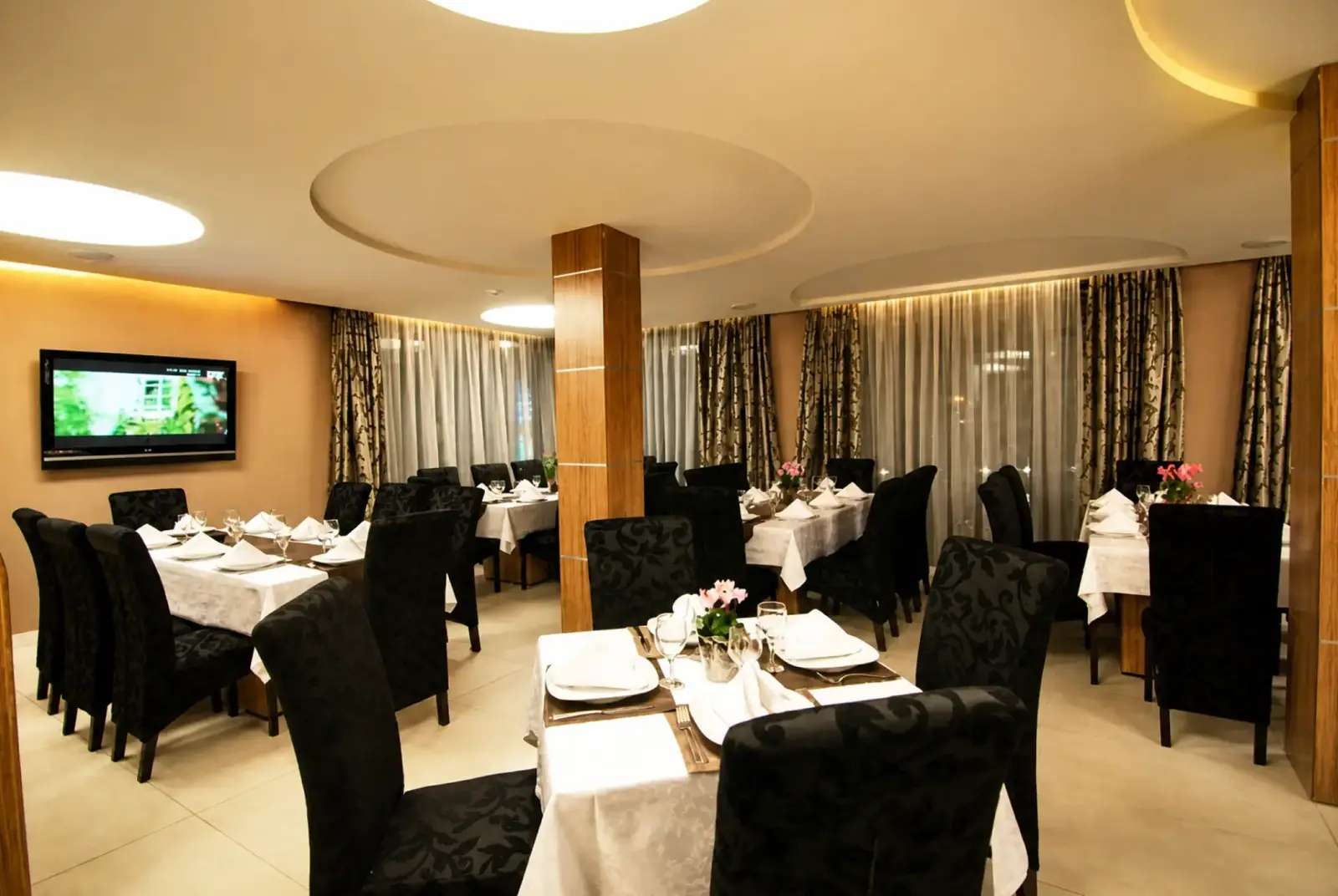 Restaurant at Hotel Ave Lux with laid tables and upholstered chairs