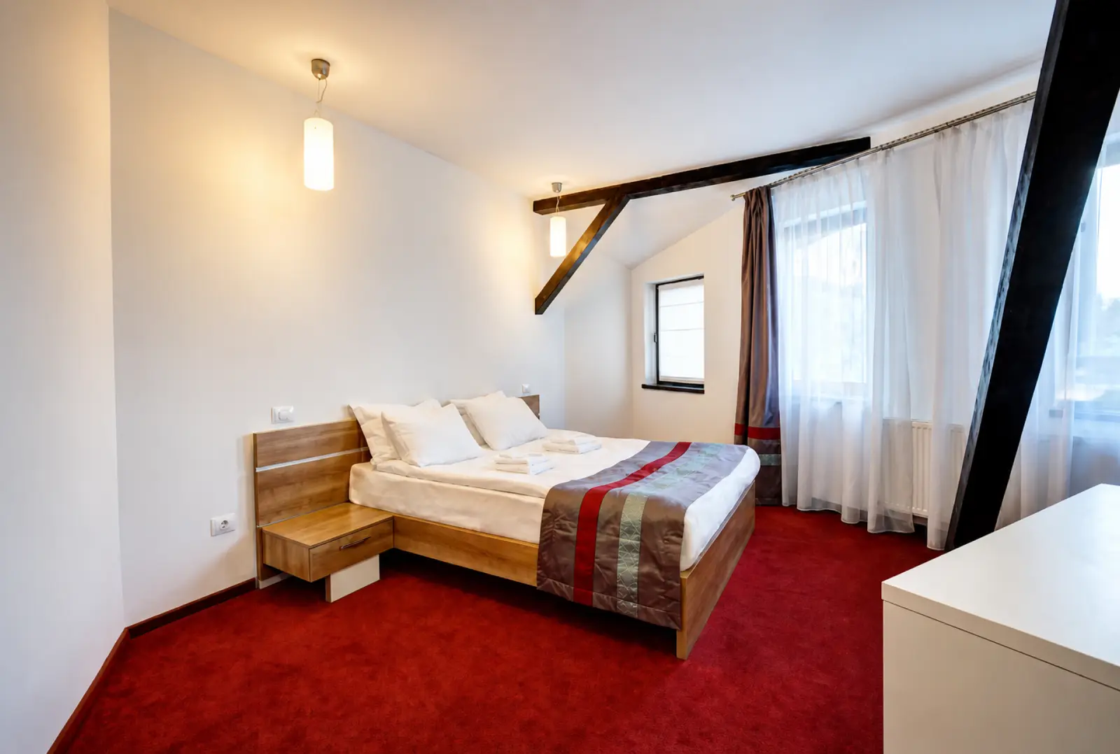 Attic room at Hotel Ave Lux with exposed beams and a double bed